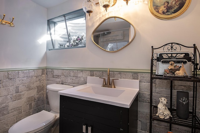 bathroom with toilet, tile walls, and wainscoting