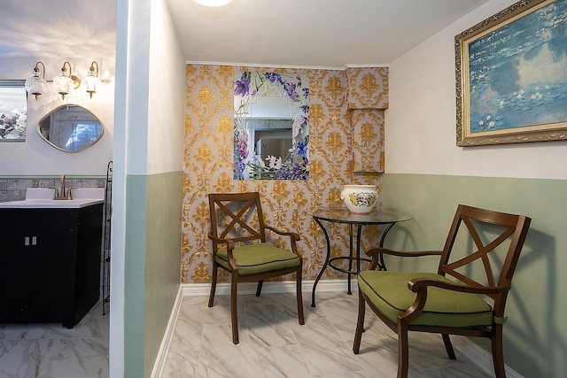 sitting room featuring marble finish floor, baseboards, and wallpapered walls