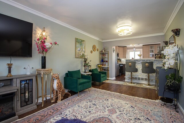 living room featuring baseboards, wood finished floors, and crown molding