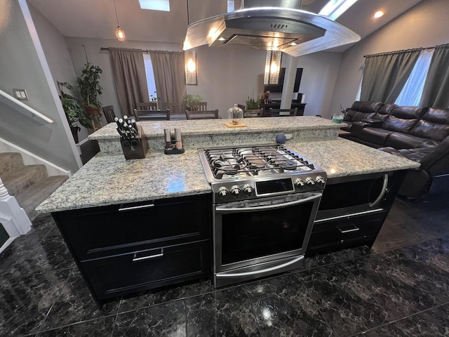 kitchen featuring light stone countertops, gas range, a kitchen island, and open floor plan