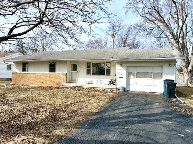 ranch-style home with an attached garage, aphalt driveway, and brick siding