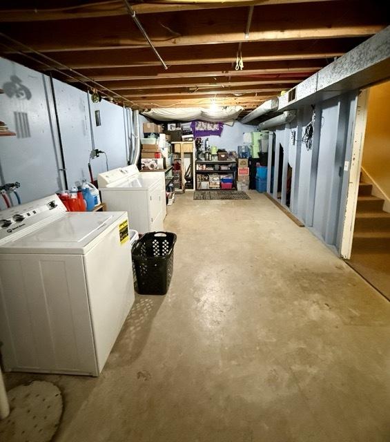 unfinished below grade area with stairs and washing machine and clothes dryer