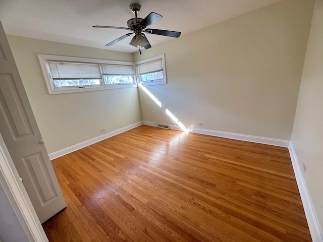 spare room with light wood-type flooring, visible vents, baseboards, and ceiling fan