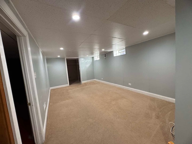 basement with baseboards, recessed lighting, and light colored carpet