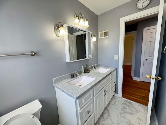 bathroom featuring marble finish floor, baseboards, visible vents, and a sink