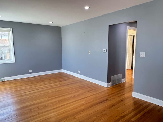 spare room with recessed lighting, visible vents, baseboards, and wood finished floors