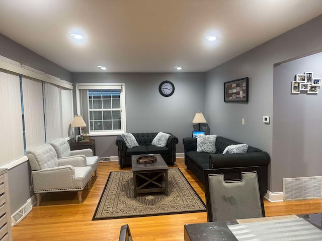 living area with light wood finished floors, baseboards, and visible vents