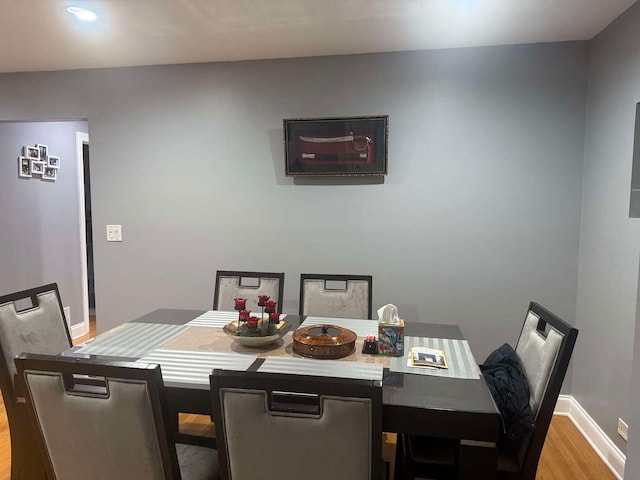 dining area featuring light wood finished floors and baseboards