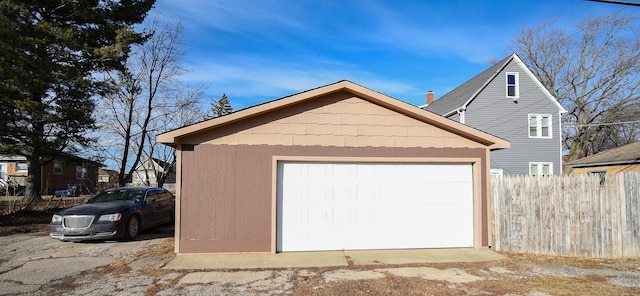 detached garage featuring fence