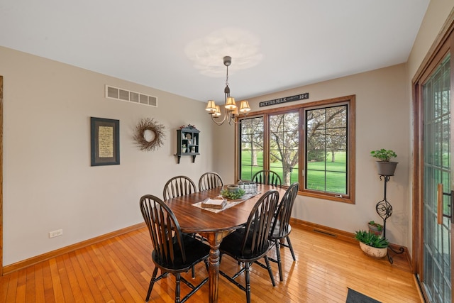 dining space featuring an inviting chandelier, light wood-style floors, visible vents, and baseboards