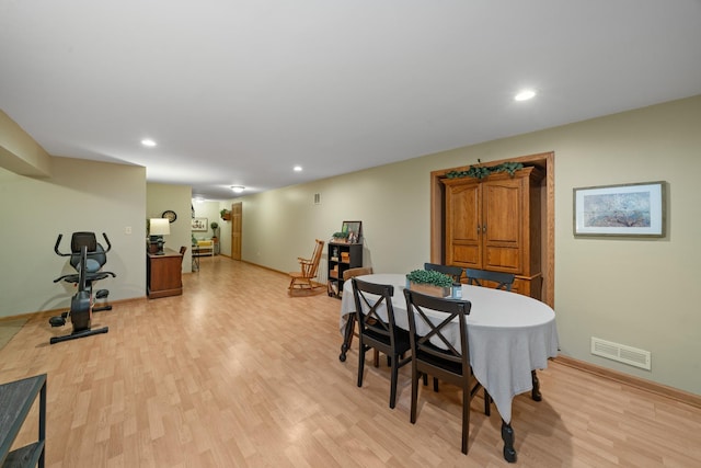 dining area featuring baseboards, light wood-type flooring, and visible vents
