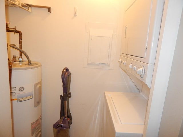 laundry area with stacked washer / dryer, electric panel, electric water heater, and laundry area