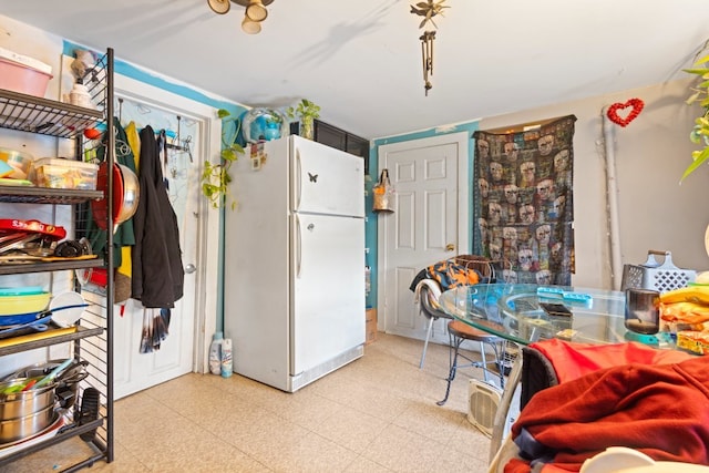 kitchen with light floors and freestanding refrigerator