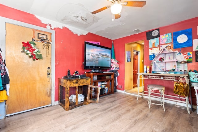 living area with visible vents, ceiling fan, baseboards, and wood finished floors