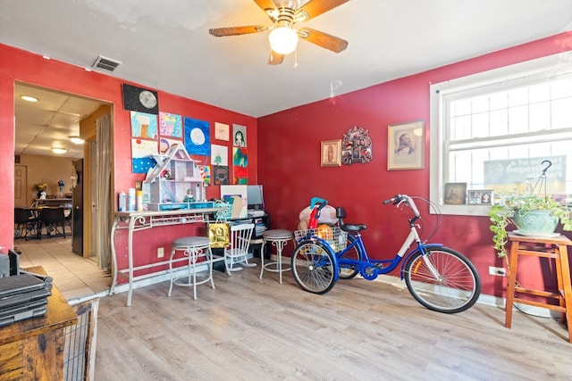 interior space with baseboards, ceiling fan, visible vents, and wood finished floors