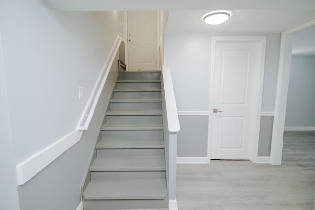 stairway with baseboards and wood finished floors