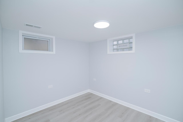 finished below grade area featuring light wood-type flooring, visible vents, and baseboards