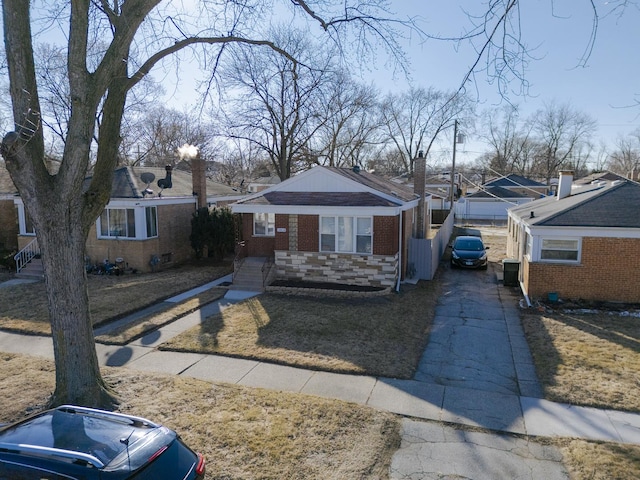 bungalow-style home with brick siding and driveway