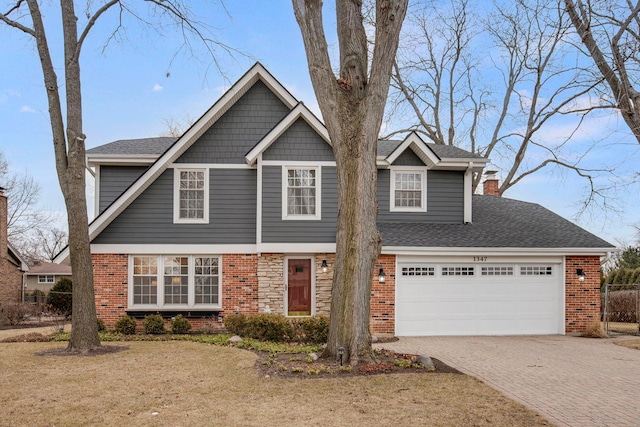 view of front of house with a shingled roof, decorative driveway, brick siding, and an attached garage