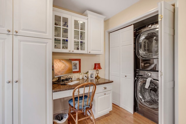 laundry area featuring laundry area, light wood-style flooring, and stacked washer and clothes dryer