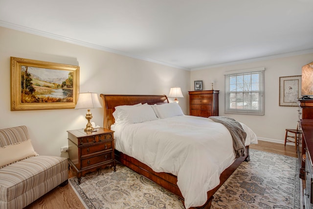 bedroom featuring light wood-style floors, baseboards, and crown molding