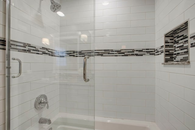 bathroom with shower / bath combination with glass door