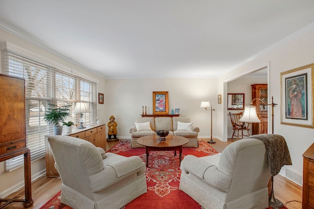 living area featuring light wood-type flooring, visible vents, crown molding, and baseboards