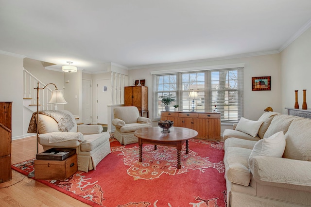 living area featuring baseboards, crown molding, stairway, and wood finished floors