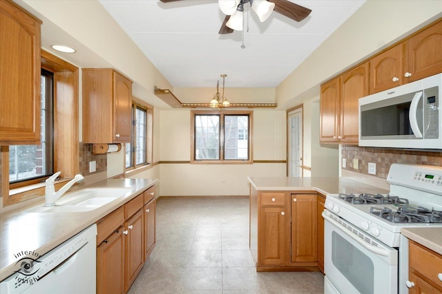 kitchen featuring light countertops, white appliances, a sink, and decorative backsplash