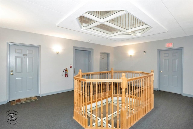 corridor featuring carpet floors, an upstairs landing, and baseboards