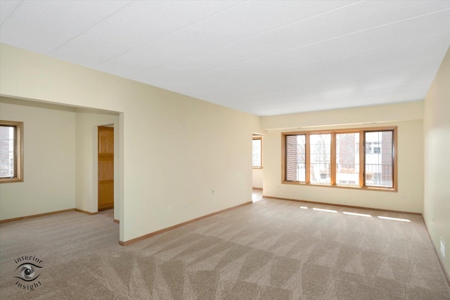 unfurnished room with a healthy amount of sunlight, baseboards, and carpet floors