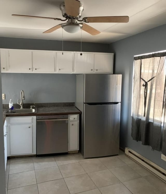 kitchen with a baseboard heating unit, appliances with stainless steel finishes, a sink, and white cabinetry