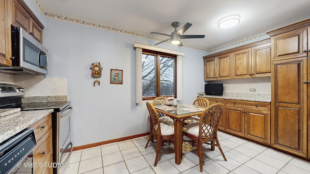 kitchen featuring backsplash, appliances with stainless steel finishes, brown cabinetry, ceiling fan, and baseboards