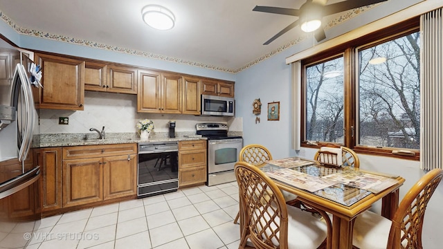 kitchen with stainless steel appliances, brown cabinetry, and a sink