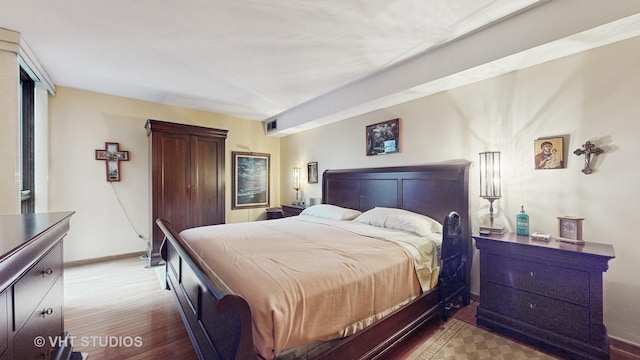 bedroom with visible vents, baseboards, and wood finished floors