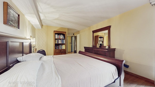 bedroom with wood finished floors and baseboards