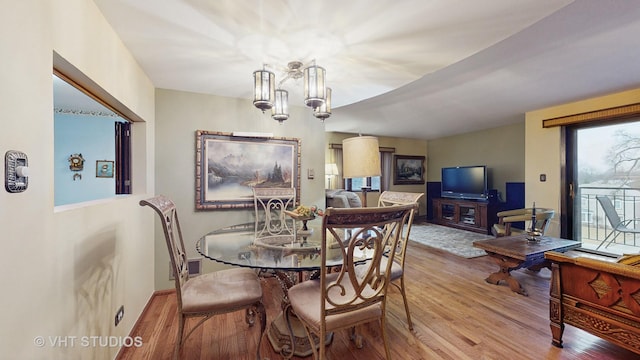 dining area with a chandelier, visible vents, and wood finished floors