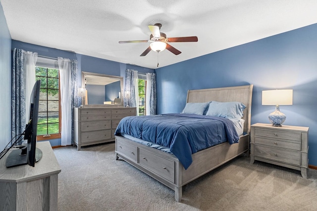 bedroom featuring ceiling fan, multiple windows, carpet, and a textured ceiling