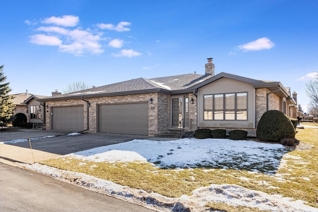 view of front of house featuring a garage, concrete driveway, brick siding, and a chimney