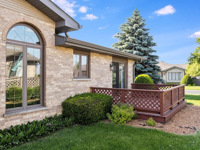 exterior space featuring brick siding and a wooden deck