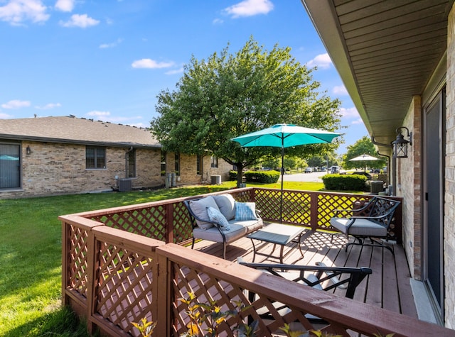 wooden terrace featuring outdoor lounge area, central AC, and a yard