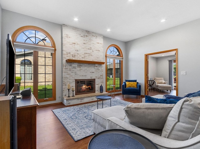 living area featuring recessed lighting, a fireplace, and wood finished floors