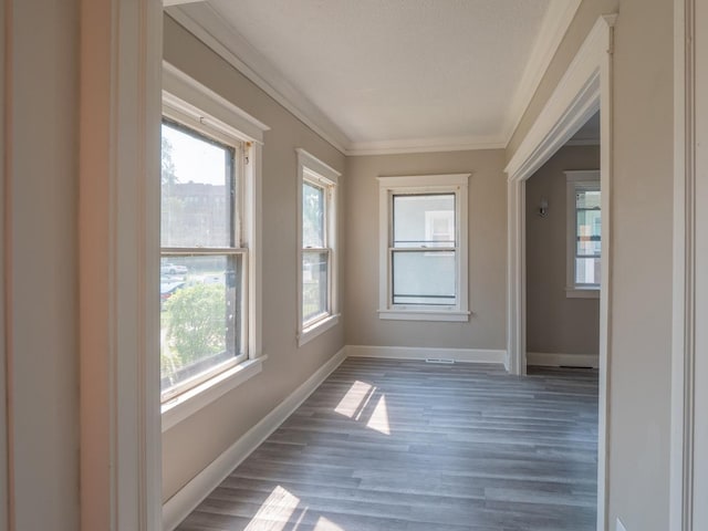 interior space featuring crown molding, a textured ceiling, baseboards, and wood finished floors