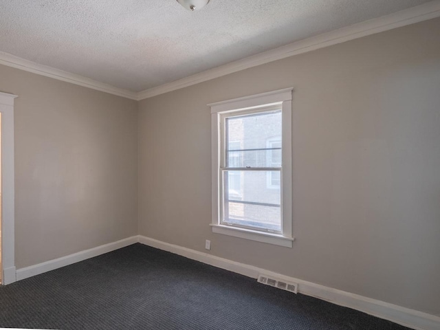 empty room with a textured ceiling, visible vents, baseboards, ornamental molding, and dark colored carpet