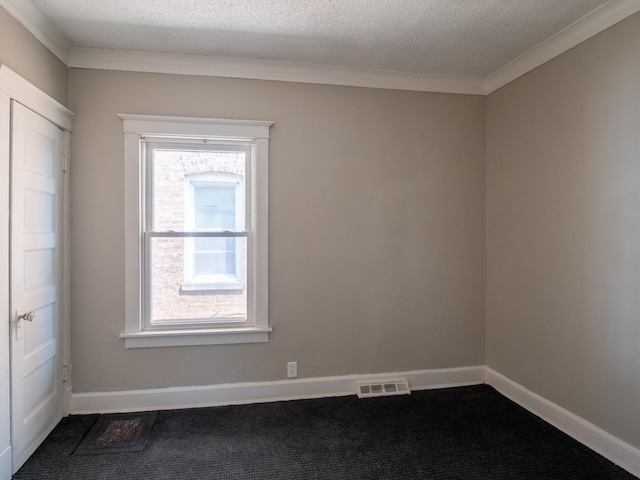 unfurnished room with dark colored carpet, a healthy amount of sunlight, visible vents, and baseboards