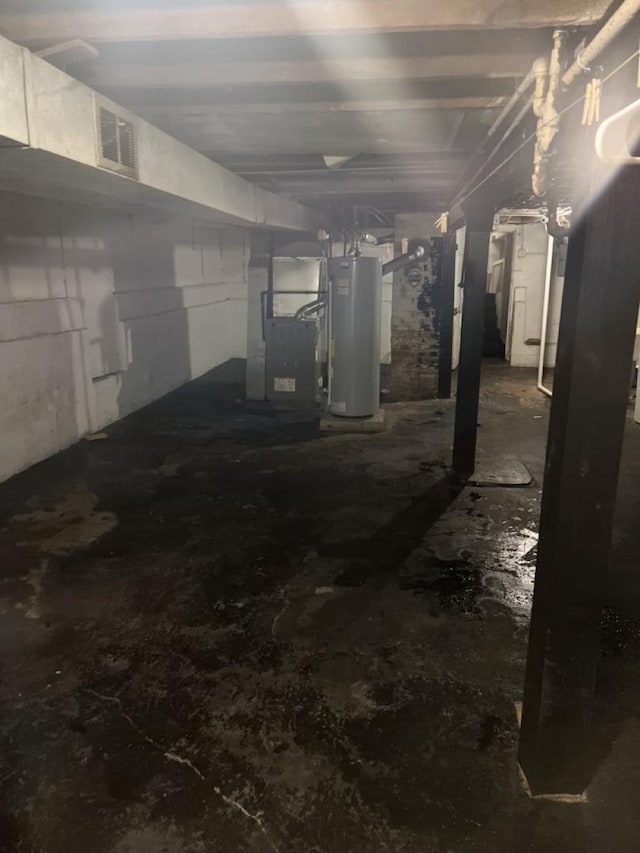 unfinished basement featuring gas water heater, visible vents, and heating unit