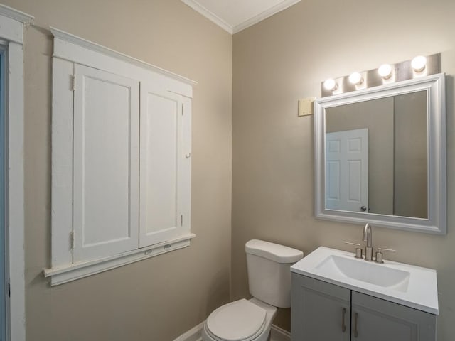 bathroom featuring ornamental molding, vanity, and toilet