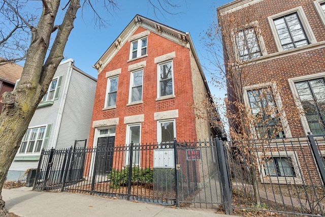 view of front of property featuring a fenced front yard and brick siding