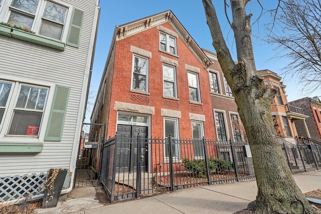 exterior space with a fenced front yard and brick siding