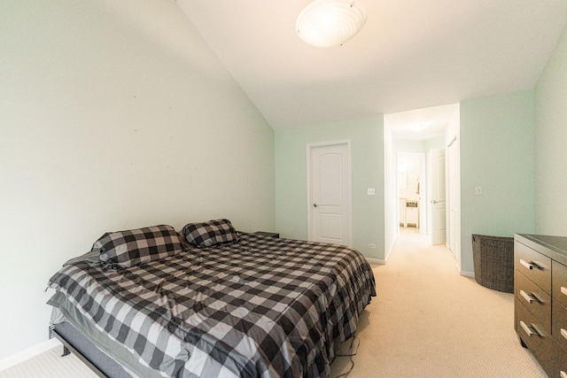 bedroom featuring lofted ceiling, baseboards, and light colored carpet